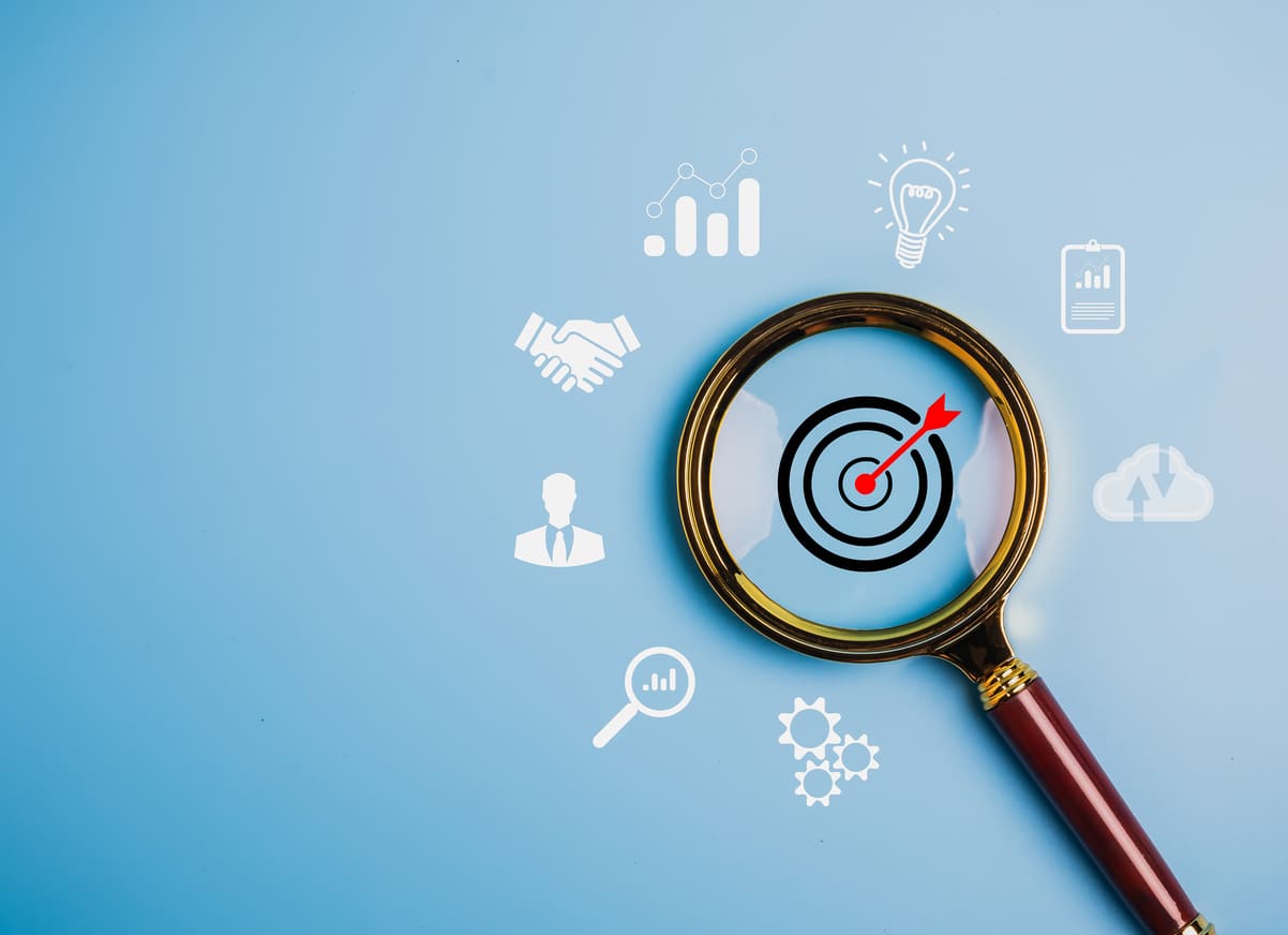 Magnifier glass focus to target dartboard, marketing strategy and action plan to attract the right clients to website concept